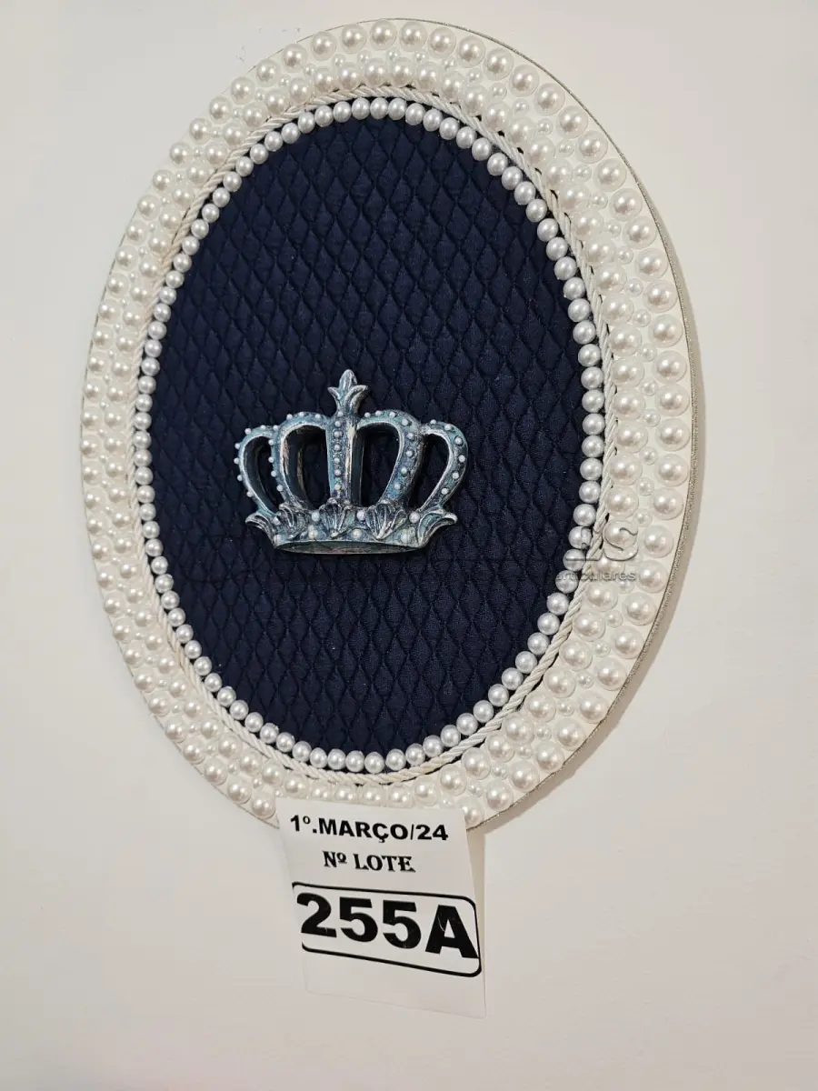 LOTE 255 - 01 QUADRO OVAL COM FUNDO EM TECIDO METALACÊ AZUL MARINHO, CORÔA DE RESINA ENVELHECIDO NO TOM AZUL E COM TOQUE PRATEADO(PINTADO À MÃO) E FINALIZADA NO VENIZ COM PÉROLAS BRANCAS (MEDIDAS: 40CMX32CM) (NOVO) (NO ESTADO)