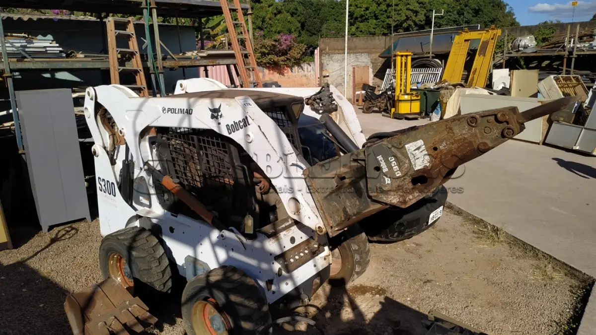 LOTE 176 - 01 MINI CARREGADEIRA BOBCAT S300 A DISEL COM 02 IMPLEMENTOS, ANO 2004. (NO ESTADO EM QUE SE ENCONTRA. SUJEITO A AVARIAS OCULTAS/VISÍVEIS.) AV9497M
