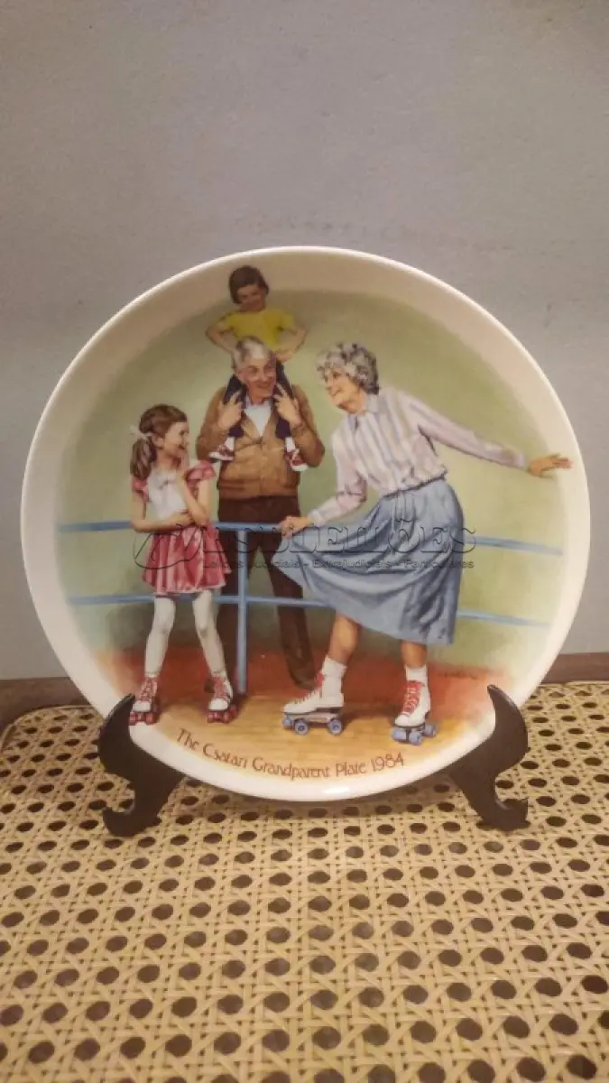 LOTE 258 - 01 PRATO THE BRADFORD EXCHANGE, EDWARD M. KNOWLES AMERICA, O NOME MAIS ANTIGO DA PORCELANA FINA DESDE 1854. PRATO DOS AVÓS DO CSATARI, COM 21 CM DE DIÂMETRO 1984. "A RAINHA DA PATINAGEM" EM INGLES "THE SKATING QUEEN" ESTE PRATO REQUINTADO, CRIADO PELO RENOMADO ARTISTA JOSEPH CSATARI, RETRATA A ALEGRIA E O AMOR COMPARTILHADOS ENTRE AVÓS E NETOS. FEITO COM A MAIS FINA PORCELANA, ESTE PRATO É UMA VERDADEIRA OBRA DE ARTE. PRATO NÚMERO 1295B.COM CERTIFICADO, CAIXA, E FOLHETO DO MESMO EM EXCELENTE ESTADO.ITEM COMPRADO E GARAGENS DE ANTIGUIDADES NOS EUA. SUPORTE PARA PRATO NÃO INCLUÍDO NESTA VENDA. (NO ESTADO) ATENÇÃO! FAZER A VISITAÇÃO ANTES DE ARREMATAR, NÃO SABEMOS SE FUNCIONA, LEILÃO NÃO TEM GARANTIA E NEM DEVOLUÇÃO, SUJEITO A POSSÍVEIS AVARIAS VISÍVEIS/OCULTAS E/OU AUSÊNCIA DE COMPONENTES.