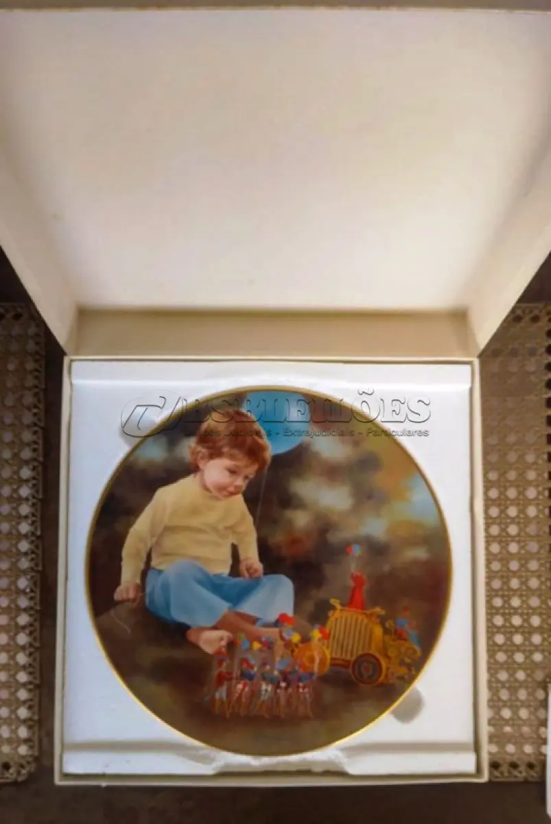 LOTE 238 - 01 RARO PRATO DE COLECIONADOR LYNN LUPETTI MAGIC PEOPLE FANTASY FESTIVAL É UMA ADIÇÃO VIBRANTE A QUALQUER COLEÇÃO, COM 26 CM DE DIÂMETRO. PRATO APRESENTA UM PADRÃO LÚDICO DE UM MENINO EM MEIO A UMA PAISAGEM MÁGICA E FANTÁSTICA, LINDAMENTE REPRESENTADO EM TONS DE AZUL E VERMELHO. CRIADO NOS ESTADOS UNIDOS EM 1982, ELE REMONTA AO FINAL DO SÉCULO XX, REFLETINDO A ARTE E O ESTILO DA DÉCADA DE 1980. FORAM LANÇADAS APENAS 10 MIL PEÇAS ESSE E O PRATO DE NUMERO 3638. UMA TÉCNICA DE PRODUÇÃO EM CERÂMICA ARTÍSTICA, ESTE ITEM DE COLECIONADOR FOI PROJETADO PARA SER EXIBIDO E APRECIADO EM TODAS AS OCASIÕES. O PRATO É UM TESTEMUNHO DA ESTÉTICA DA ÉPOCA, APRESENTANDO UM TEMA NOSTÁLGICO DE CRIANÇAS QUE CAPTURA A IMAGINAÇÃO E O ESPÍRITO DA ÉPOCA. SEJA VOCÊ UM COLECIONADOR EXPERIENTE OU SIMPLESMENTE UM APRECIADOR DO CHARME DE ITENS VINTAGE, ESTA PEÇA CERTAMENTE ENCANTARÁ.ITEM COMPRADO E GARAGENS DE ANTIGUIDADES NOS EUA.SUPORTE PARA PRATO NÃO INCLUÍDO NESTA VENDA. (NO ESTADO) ATENÇÃO! FAZER A VISITAÇÃO ANTES DE ARREMATAR, NÃO SABEMOS SE FUNCIONA, LEILÃO NÃO TEM GARANTIA E NEM DEVOLUÇÃO, SUJEITO A POSSÍVEIS AVARIAS VISÍVEIS/OCULTAS E/OU AUSÊNCIA DE COMPONENTES.