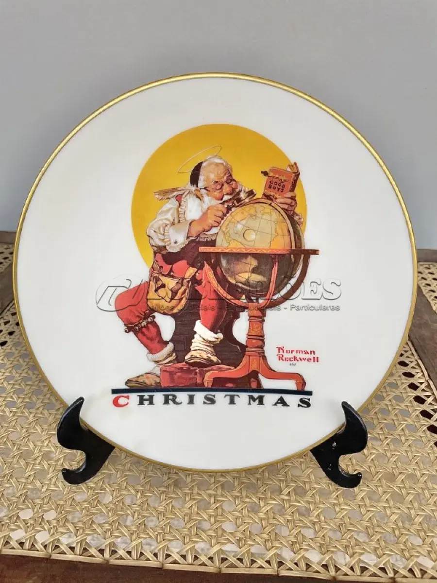 LOTE 224 - 01 BELO PRATO DE COLECIONADOR DE NORMAN ROCKWELL APRESENTA A EMOCIONANTE CENA DE "PLANEJANDO VISITAS DE NATAL" E É UM ITEM ESSENCIAL PARA QUALQUER COLEÇÃO. TEM BORDAS A OURO 24 K  COM 21,5 CM DE DIÂMETRO E É REPLETO DE DETALHES INTRINCADOS E CORES VIBRANTES QUE DÃO VIDA À CENA. O PRATO FOI FABRICADO NA DÉCADA DE 1970 PELA GORHAM, NOS ESTADOS UNIDOS. É UM ITEM VINTAGE E ESTÁ EM ÓTIMO ESTADO, PRONTO PARA SER EXIBIDO E APRECIADO POR MUITOS ANOS. ESTE SERIA UM PRESENTE PERFEITO PARA QUALQUER COLECIONADOR OU AMANTE DA OBRA DE NORMAN ROCKWELL.ITEM COMPRADO EM GARAGENS DE ANTIGUIDADES NOS EUA. SUPORTE PARA PRATO NÃO INCLUÍDO NESTA VENDA. (NO ESTADO) ATENÇÃO! FAZER A VISITAÇÃO ANTES DE ARREMATAR, NÃO SABEMOS SE FUNCIONA, LEILÃO NÃO TEM GARANTIA E NEM DEVOLUÇÃO, SUJEITO A POSSÍVEIS AVARIAS VISÍVEIS/OCULTAS E/OU AUSÊNCIA DE COMPONENTES.