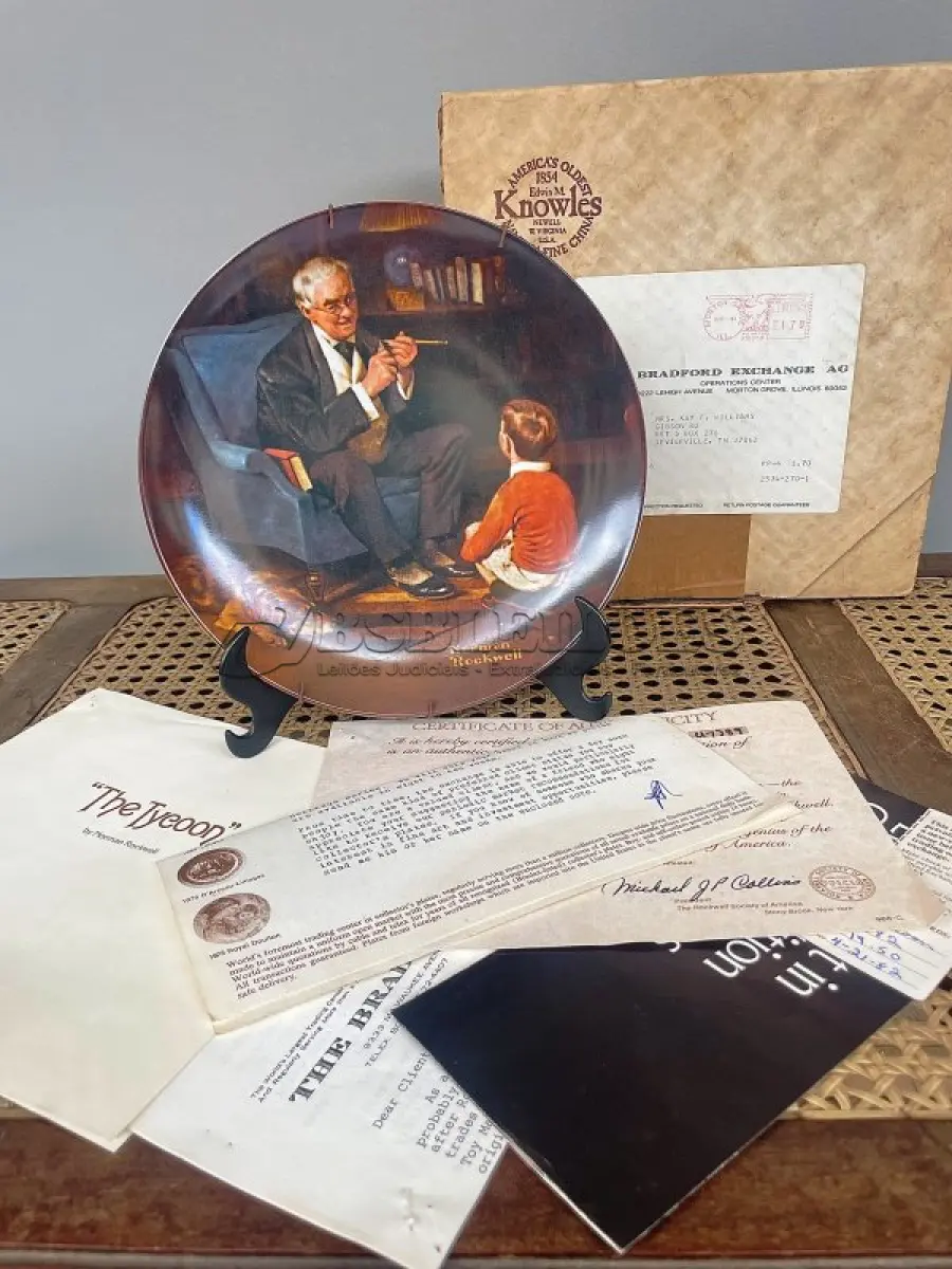 LOTE 269 - 01 PRATO VINTAGE NORMAN ROCKWELL EDIÇÃO LIMITADA "THE TYCOON"O MAGNATA" É NUMERADO U7789. CONFORME INDICADO NO VERSO, É "DA ÚNICA EDIÇÃO LIMITADA DE "THE TYCOON" DE NORMAN ROCKWELL. SEXTO NA COLEÇÃO ROCKWELL HERITAGE. FABRICADO EM UMA EDIÇÃO LIMITADA PERMANENTEMENTE FECHADA EM 1982 PELA KNOWLES E CERTIFICADO COMO UM VERDADEIRO CLÁSSICO ROCKWELL PELA ROCKWELL SOCIETY OF AMERICA. NÚMERO BRADEX DO PRATO: 84-R70-3.6. DIÂMETRO 8,5". ESTE PRATO DE COLECIONADOR É DA SÉRIE HERITAGE. UM PRESENTE PERFEITO PARA COLECIONADORES NORMAN ROCKWELL, PARA DECORAÇÃO CLÁSSICA. COM NOTA DE COMPRA EM, 21/04/1982 COM TODOS FOLHETOS DA ÉPOCA.ITEM COMPRADO EM GARAGEM DE ANTIGUIDADES NOS EUA. SUPORTE PARA PRATO NÃO INCLUÍDO NESTA VENDA. (NO ESTADO) ATENÇÃO! FAZER A VISITAÇÃO ANTES DE ARREMATAR, NÃO SABEMOS SE FUNCIONA, LEILÃO NÃO TEM GARANTIA E NEM DEVOLUÇÃO, SUJEITO A POSSÍVEIS AVARIAS VISÍVEIS/OCULTAS E/OU AUSÊNCIA DE COMPONENTES.