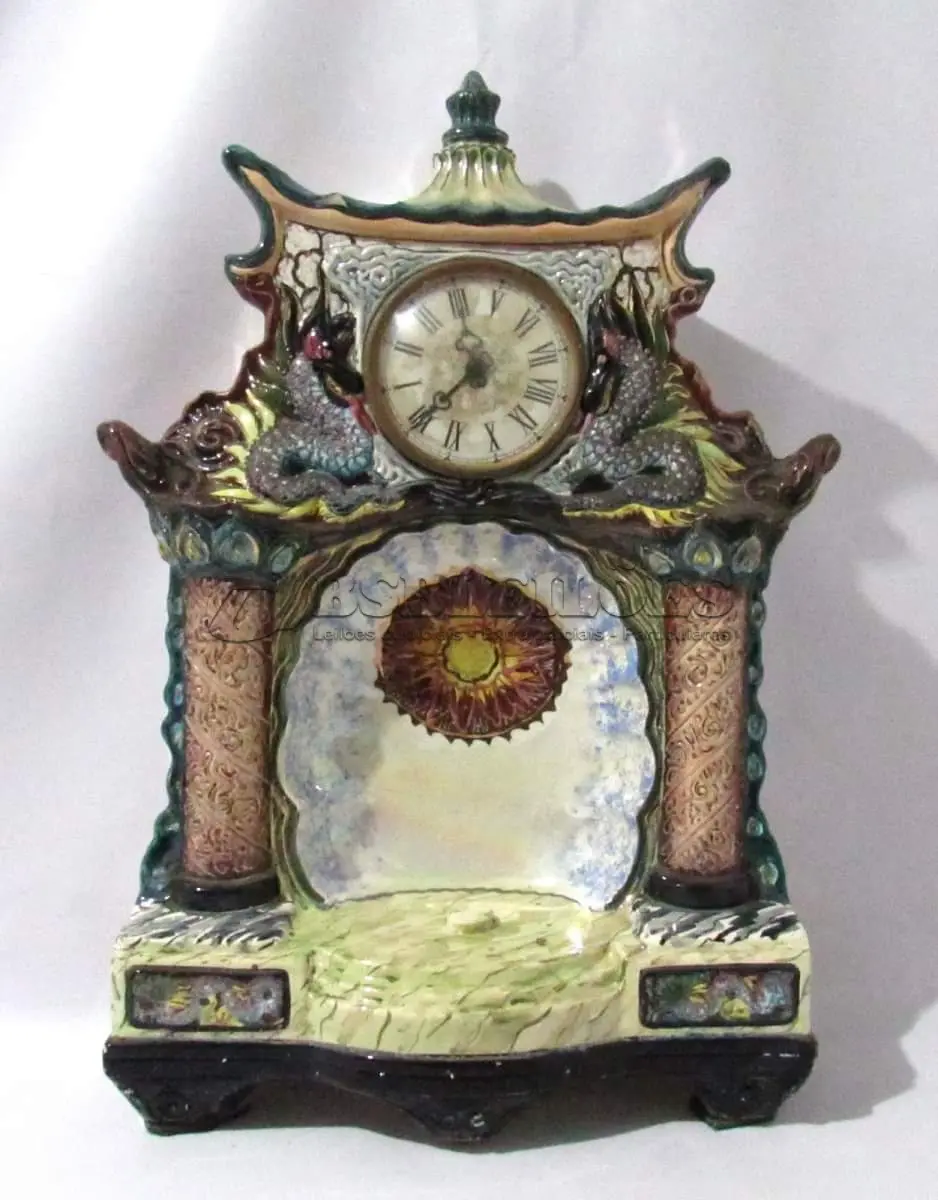 LOTE 034 - ANTIGO RELÓGIO IMPORTADO DA MARCA RUBINICH CONFECCIONADO EM FAIANÇA COM ESMALTAGEM BRANCA VITRIFICADA, CHINES  50 CM DE ALTURA X 37 CM DE LARGURA.(NO ESTADO)