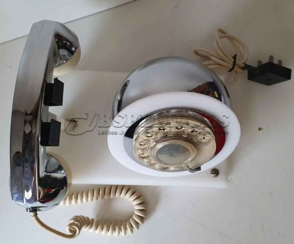 LOTE 084 - RARO TELEFONE ANOS 70. EM PLÁSTICO CROMADO E MECANISMO EM CAIXA DE ACRÍLICO MEDIDAS 24 CM COMP X 14,5 CM LARG X 19 CM ALT (NO ESTADO)