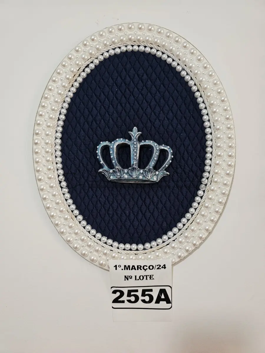 LOTE 255 - 01 QUADRO OVAL COM FUNDO EM TECIDO METALACÊ AZUL MARINHO, CORÔA DE RESINA ENVELHECIDO NO TOM AZUL E COM TOQUE PRATEADO(PINTADO À MÃO) E FINALIZADA NO VENIZ COM PÉROLAS BRANCAS (MEDIDAS: 40CMX32CM) (NOVO) (NO ESTADO)