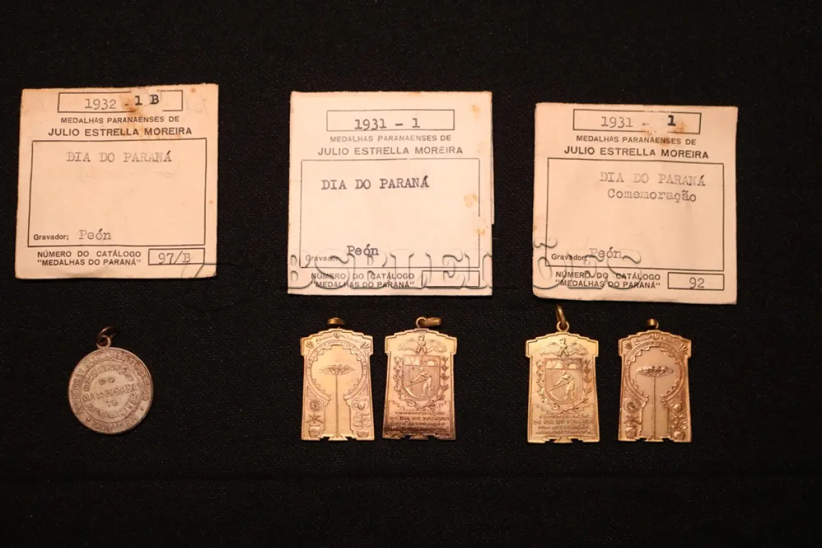 LOTE 013 - LOTE 13 – MEDALHAS – DIA DO PARANÁ 	MEDALHA	OBSERVAÇÕES 1.		Dia do Paraná. Associação Paranaense de Imprensa. 1932. Gravador: José Peon	Prateada 2.		Comemoração do Dia do Paraná. Ass. Paranaense de Imprensa. 1931. Gravador: José Peon	Dourada - envelope da Coleção Júlio Estrella Moreira 3.		Comemoração do Dia do Paraná. Ass. Paranaense de Imprensa. 1931. Gravador: José Peon	Dourada 4.		Comemoração do Dia do Paraná. Ass. Paranaense de Imprensa. 1931. Gravador: José Peon	Dourada 5.		Comemoração do Dia do Paraná. Ass. Paranaense de Imprensa. 1931. Gravador: José Peon	Dourada