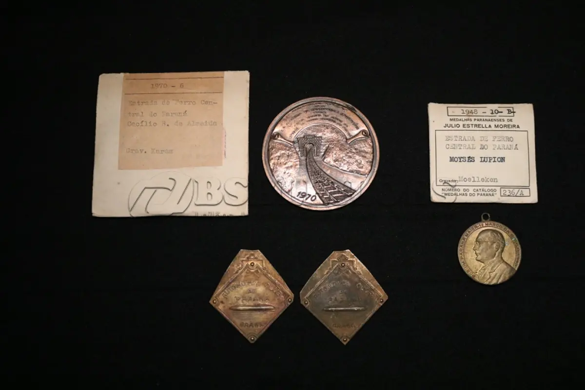 LOTE 017 - LOTE 17 – MEDALHAS FERROVIA 	MEDALHA	OBSERVAÇÕES 1.		Medalhão da Estrada de Ferro Central do Paraná. 1970 Gravador: José Mansur Karam	Acobreada – reverso liso - envelope de época  2.		1° Marco da Estrada de Ferro Central do Paraná.1948 Homenagem ao Governador Moyses Lupion.Gravador: João Moelleken	Dourada - envelope da Coleção Júlio Estrella Moreira 3.		Automóvel Clube do Paraná.	Dourada – Prova de cunho 4.		Automóvel Clube do Paraná.	Dourada – Prova de cunho