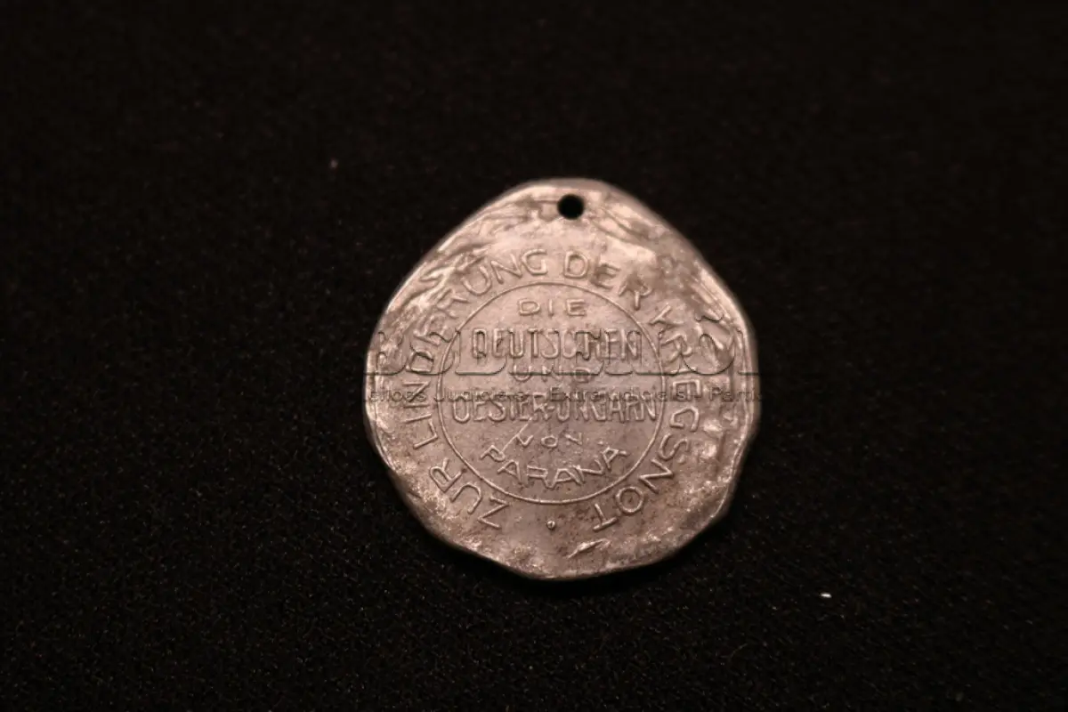 LOTE 036 - LOTE 36 – MEDALHAS ALEMANHA 	MEDALHA	OBSERVAÇÕES 1.		Cruz de Ferro Alemã. 1914 Gravador: José Peón	Reverso liso - envelope da Coleção Júlio Estrella Moreira 2.		Beneficente da Cruz Vermelha Austro-Alemã. 1915	Prateada - envelope da Coleção Júlio Estrella Moreira 3.		Deustche Woche (Semana Alemã). 1937. Curitiba Gravador: Eduardo Muller	Reverso liso - envelope da Coleção Júlio Estrella Moreira 4.		Águia Alemã com pergaminho Gravador: Henrique Kaminski – A Pérola	Reverso liso - envelope da Coleção Júlio Estrella Moreira