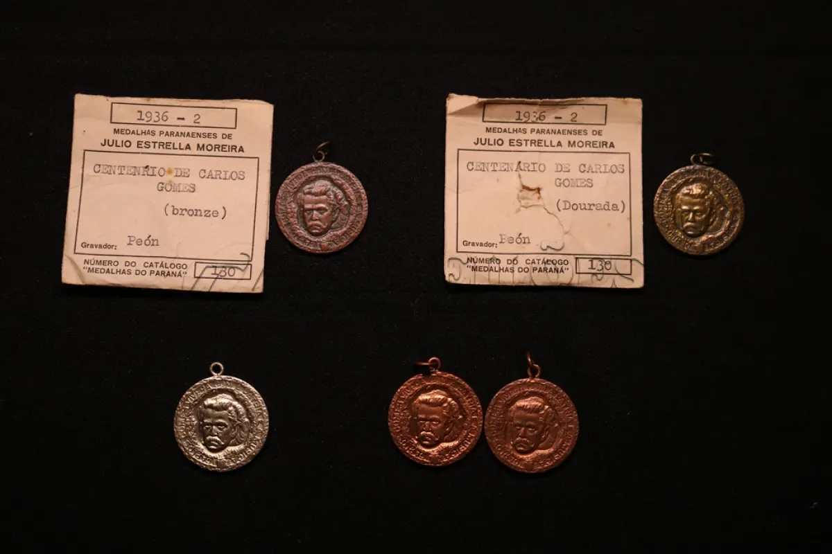 LOTE 028 - LOTE 28 – MEDALHAS MAESTRO CARLOS GOMES 	MEDALHA	OBSERVAÇÕES 1.		Centenário do Maestro Carlos Gomes. 1936 Gravador: José Peón	Bronzeada – envelope da Coleção Júlio Estrella Moreira 2.		Centenário do Maestro Carlos Gomes. 1936 Gravador: José Peón	Dourada – envelope da Coleção Júlio Estrella Moreira 3.		Centenário do Maestro Carlos Gomes. 1936 Gravador: José Peón	Prateada 4.		Centenário do Maestro Carlos Gomes. 1936 Gravador: José Peón	Acobreada 5.		Centenário do Maestro Carlos Gomes. 1936 Gravador: José Peón	Acobreada