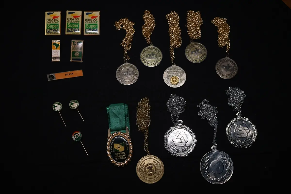LOTE 045 - LOTE 45 – BANESTADO 	OBJETO	OBSERVAÇÕES 1.		Medalha Prateada Banestado – sem uso	3 unidades 2.		Medalha Associação Banestado – Inauguração Ginásio de Esportes-  30 de outubro de 1982	5 unidades 3.		Pin Banestado Feira do Paraná Super Plus Titulo de Capitalização.	3 unidades 4.		Pin CIN Centro Internacional de Negócios -  Banestado	1 unidade 5.		Pin 8ª Assembleia Geral da Federação Luterana Mundial – 1998 - Banestado	1 unidade 6.		Crachá de funcionário Banestado em metal	1 unidade 7.		Medalha Campeonato Paranaense de Natação – Associação Masters do Paraná. 2000. Banestado	1 unidade 8.		Medalha Honra ao Mérito - Banestado	1 unidade 9.		Alfinete de Lapela Banestado – Foz do Iguacu	1 unidade 10.		Alfinete de Lapela Banestado – Pato Branco	2 unidade