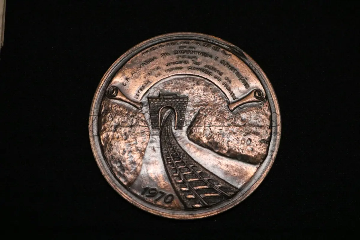 LOTE 017 - LOTE 17 – MEDALHAS FERROVIA 	MEDALHA	OBSERVAÇÕES 1.		Medalhão da Estrada de Ferro Central do Paraná. 1970 Gravador: José Mansur Karam	Acobreada – reverso liso - envelope de época  2.		1° Marco da Estrada de Ferro Central do Paraná.1948 Homenagem ao Governador Moyses Lupion.Gravador: João Moelleken	Dourada - envelope da Coleção Júlio Estrella Moreira 3.		Automóvel Clube do Paraná.	Dourada – Prova de cunho 4.		Automóvel Clube do Paraná.	Dourada – Prova de cunho