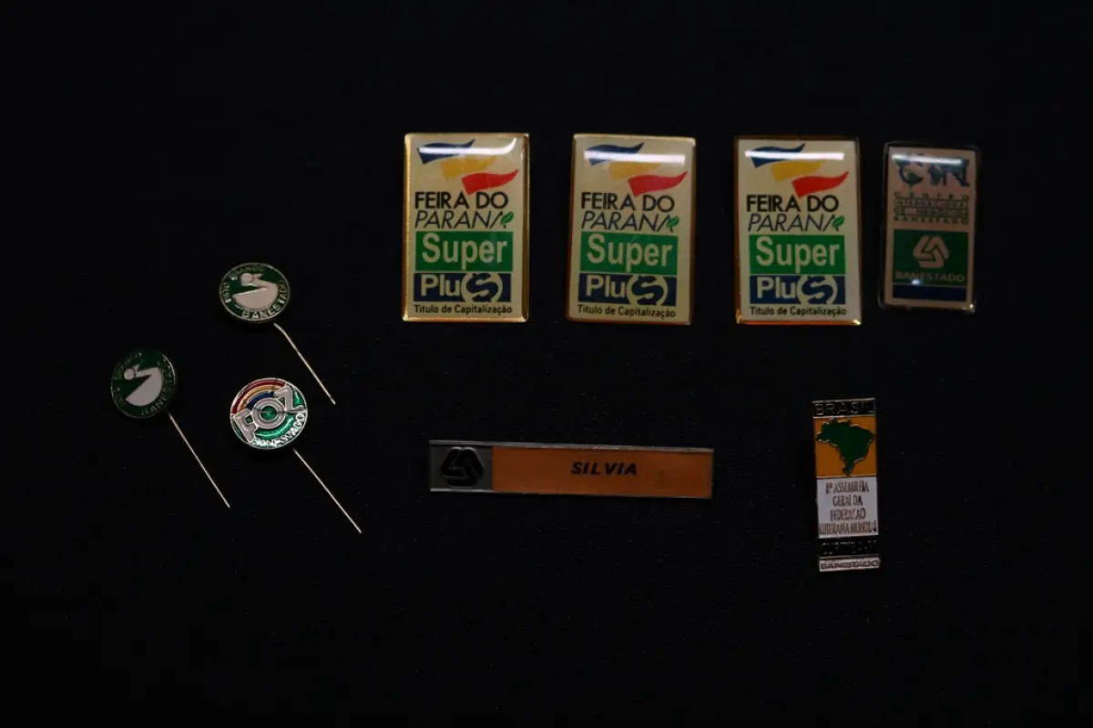 LOTE 045 - LOTE 45 – BANESTADO 	OBJETO	OBSERVAÇÕES 1.		Medalha Prateada Banestado – sem uso	3 unidades 2.		Medalha Associação Banestado – Inauguração Ginásio de Esportes-  30 de outubro de 1982	5 unidades 3.		Pin Banestado Feira do Paraná Super Plus Titulo de Capitalização.	3 unidades 4.		Pin CIN Centro Internacional de Negócios -  Banestado	1 unidade 5.		Pin 8ª Assembleia Geral da Federação Luterana Mundial – 1998 - Banestado	1 unidade 6.		Crachá de funcionário Banestado em metal	1 unidade 7.		Medalha Campeonato Paranaense de Natação – Associação Masters do Paraná. 2000. Banestado	1 unidade 8.		Medalha Honra ao Mérito - Banestado	1 unidade 9.		Alfinete de Lapela Banestado – Foz do Iguacu	1 unidade 10.		Alfinete de Lapela Banestado – Pato Branco	2 unidade