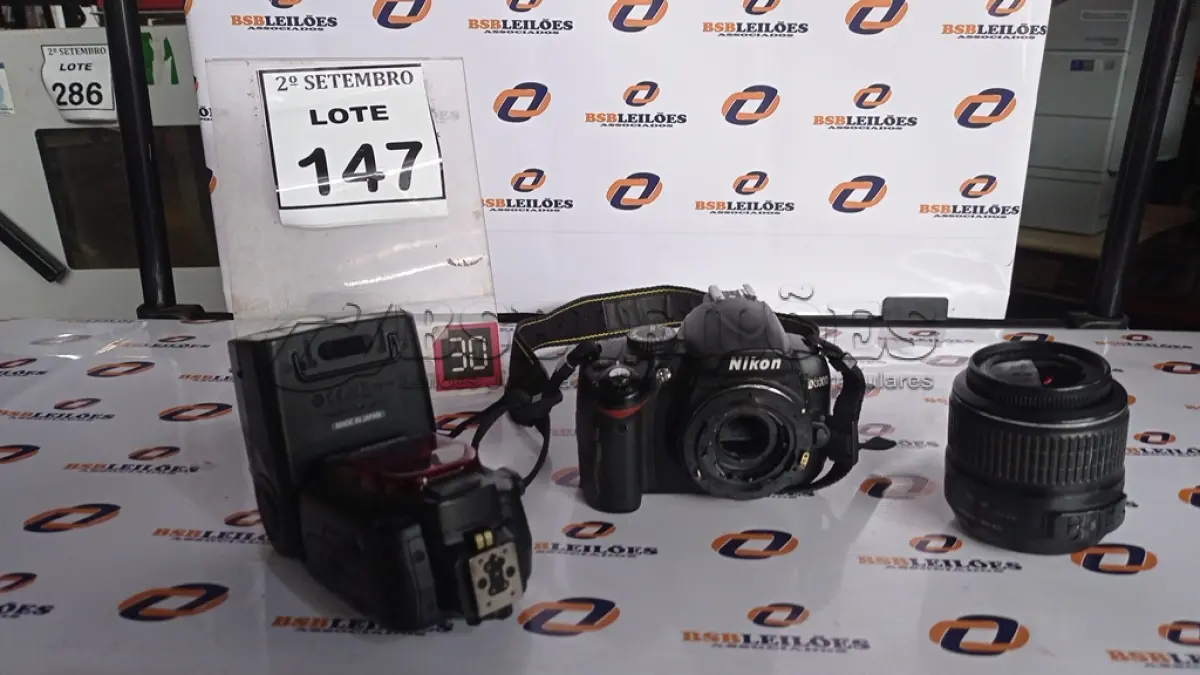 LOTE 147 - 01 MÁQUINA FOTOGRÁFICA DIGITAL MARCA NIKON MARCA D3000 COM LENTE E 01 FLASH. (NO ESTADO) ATENÇÃO! FAZER A VISITAÇÃO ANTES DE ARREMATAR, NÃO SABEMOS SE FUNCIONA, LEILÃO NÃO TEM GARANTIA E NEM DEVOLUÇÃO, SUJEITO A POSSÍVEIS AVARIAS VISÍVEIS/OCULTAS E/OU AUSÊNCIA DE COMPONENTES.