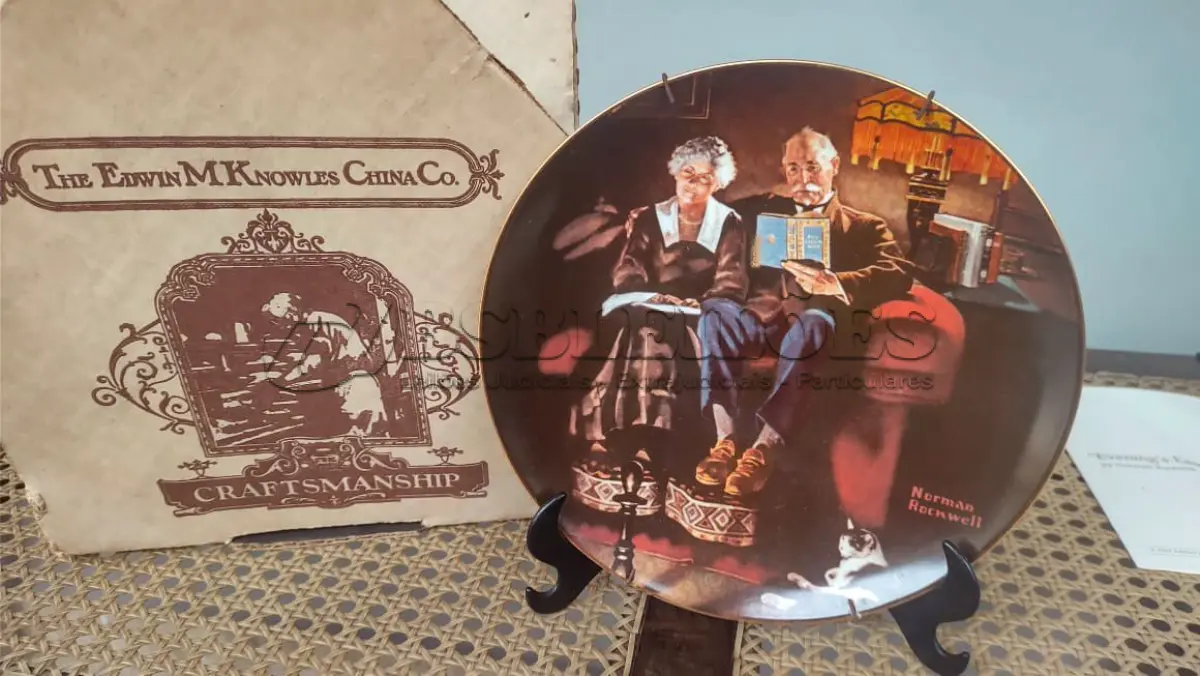 LOTE 094 - 01 BELO PRATO NORMAN ROCKWELL COM 21,5 CM DE DIÂMETRO APRESENTA A ICÔNICA OBRA DE ARTE DE NORMAN ROCKWELL INTITULADA "EVENING'S EASE". FABRICADO NOS ESTADOS UNIDOS DURANTE A DÉCADA DE 1980, ESTE PRATO MULTICOLORIDO RETRATA A CENA SERENA DE UMA MULHER DESFRUTANDO DE UM MOMENTO DE PAZ EM SUA VARANDA. UMA ÓTIMA ADIÇÃO A QUALQUER COLEÇÃO DE ITENS DECORATIVOS COLECIONÁVEIS. FEITO EM UMA EDIÇÃO ESTRITAMENTE LIMITADA A 50 DIAS DE QUEIMA NOS EUA. POR KNOWLES, O NOME MAIS ANTIGO DA AMÉRICA EM FINE PORCELANA CHINA. ITEM DE COLECIONADOR, CAIXA ORIGINAL E COM CERTIFICADO DE AUTENTICIDADE. SUPORTE PARA PRATO NÃO INCLUÍDO NESTA VENDA. (NO ESTADO) ATENÇÃO! FAZER A VISITAÇÃO ANTES DE ARREMATAR, NÃO SABEMOS SE FUNCIONA, LEILÃO NÃO TEM GARANTIA E NEM DEVOLUÇÃO, SUJEITO A POSSÍVEIS AVARIAS VISÍVEIS/OCULTAS E/OU AUSÊNCIA DE COMPONENTES.