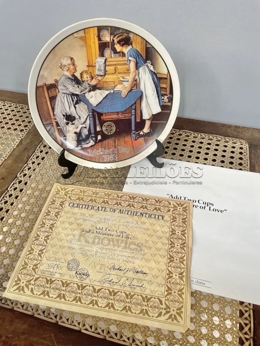 LOTE 050 - 01 RARO PRATO DE "1983 ADD TWO CUPS AND A MEASURE OF LOVE - COLLECTIBLE PORCELAIN PLATE", DE NORMAN ROCKWELL! FABRICADO PELA KNOWLES, A MARCA MAIS ANTIGA DA AMÉRICA EM PORCELANA FINA. MEDE APROXIMADAMENTE 21,5 CM DE DIÂMETRO.NO VERSO DO PRATO ESTÁ ESCRITO: "DA PRIMEIRA EDIÇÃO LIMITADA, 'ADD TWO CUPS AND A MEASURE OF LOVE', DE NORMAN ROCKWELL. O OITAVO DE UMA SÉRIE ANUAL PARA O DIA DAS MÃES. COM CERTIFICADO DE ALTENCIDADE PELA ROCKWELL SOCIETY OF AMERICA. FEITO EM EDIÇÃO LIMITADA, PERMANENTEMENTE FECHADO EM 8 DE MAIO DE 1983, POR KNOWLES.ITEM COMPRADO EM GAREGEM DE ANTIGUIDADES NOS EUA.SUPORTE PARA PRATO NÃO INCLUÍDO NESTA VENDA. (NO ESTADO) ATENÇÃO! FAZER A VISITAÇÃO ANTES DE ARREMATAR, NÃO SABEMOS SE FUNCIONA, LEILÃO NÃO TEM GARANTIA E NEM DEVOLUÇÃO, SUJEITO A POSSÍVEIS AVARIAS VISÍVEIS/OCULTAS E/OU AUSÊNCIA DE COMPONENTES.