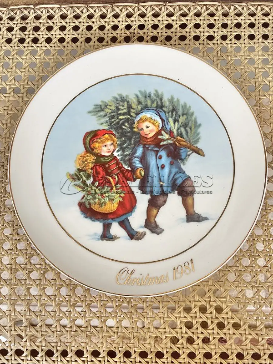 LOTE 058 - 01 PRATO DE NATAL COLECIONÁVEL DA AVON CHRISTMAS MEMORIAS DE 1981, O PRIMEIRO DA SÉRIE. COMPRANDO EM LOJA DE ANTIGUIDADES NO JAPÃO. COM ACABAMENTO EM OURO 22K, APRESENTA UMA MARAVILHOSA CENA VINTAGE DE UM MENINO E UMA MENINA LEVANDO A ÁRVORE E AS PLANTAS PARA CASA PARA AS FESTAS DE FIM DE ANO. CORES E DETALHES LINDOS. EM ÓTIMO ESTADO, COM LEVE DESGASTE NA BORDA INFERIOR DO PRATO E LEVES ARRANHÕES. COM CAIXA. TEM 23 CM DE DIÂMETRO.SUPORTE PARA PRATO NÃO INCLUÍDO NESTA VENDA. (NO ESTADO) ATENÇÃO! FAZER A VISITAÇÃO ANTES DE ARREMATAR, NÃO SABEMOS SE FUNCIONA, LEILÃO NÃO TEM GARANTIA E NEM DEVOLUÇÃO, SUJEITO A POSSÍVEIS AVARIAS VISÍVEIS/OCULTAS E/OU AUSÊNCIA DE COMPONENTES.