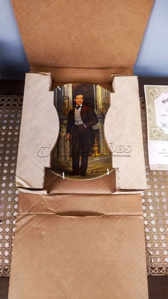 LOTE 197 - ESTE É O QUARTO PRATO NORMAN ROCKWELL DE COLECIONADOR DA COLEÇÃO E O VENTO LEVOU DE KNOWLES. FOI FEITO EM 1981 E É INTITULADO "RHETT".FEITO NOS EUA, EMPRESA DE FABRICAÇÃO KNOWLES COM A ASSISTÊNCIA DA METRO-GOLDWYN-MAYER.EDIÇÃO LIMITADA.ARTISTA RAYMOND KURSAR.ANO DE 1981.DIÂMETRO 21 CM. PRATO EM CAIXA COM CERTIFICADO, DE AUTENTICIDADE. E UM ÓTIMO COMPLEMENTO PARA QUALQUER COLEÇÃO. O PRATO FOI FABRICADO NOS ESTADOS UNIDOS NA DÉCADA DE 1981 E É CONSIDERADO UM ITEM VINTAGE. ALÉM DE SUA IMPORTÂNCIA CULTURAL COMO ITEM COLECIONÁVEL AMERICANO, ESTE PRATO TAMBÉM OSTENTA DIVERSAS CARACTERÍSTICAS, INCLUINDO O STATUS DE EDIÇÃO LIMITADA E A INCLUSÃO DA EMBALAGEM E DOCUMENTAÇÃO ORIGINAIS. É PERFEITO PARA QUALQUER OCASIÃO E UM ÓTIMO PRESENTE PARA QUALQUER COLECIONADOR OU ENTUSIASTA.O SUPORTE DO PRATO NÃO ESTÁ INCLUÍDO. (NO ESTADO) ATENÇÃO! FAZER A VISITAÇÃO ANTES DE ARREMATAR, NÃO SABEMOS SE FUNCIONA, LEILÃO NÃO TEM GARANTIA E NEM DEVOLUÇÃO, SUJEITO A POSSÍVEIS AVARIAS VISÍVEIS/OCULTAS E/OU AUSÊNCIA DE COMPONENTES.