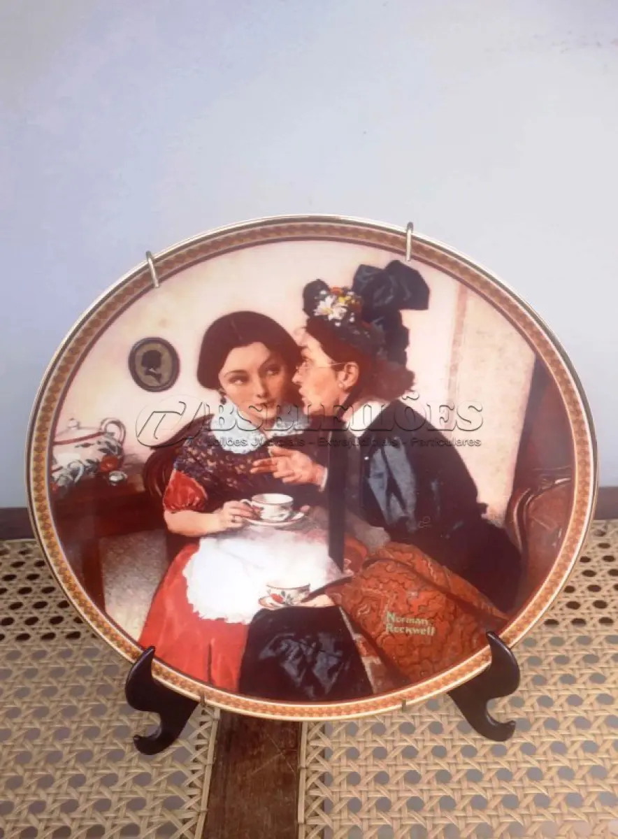 LOTE 248 - 01 PRATO DE COLECIONADOR NORMAN ROCKWELL DE 1983, FABRICADO PELA KNOWLES, A MARCA MAIS ANTIGA DA AMÉRICA EM PORCELANA FINA, FUNDADA EM 1854. ESTE PRATO É O NÚMERO 17992C  DA ÚNICA EDIÇÃO LIMITADA DE "GOSSIPING IN THE ALCOVE", DE NORMAN ROCKWELL, COM 21 CM DE DIÂMETRO SEXTA EDIÇÃO DA COLEÇÃO ROCKWELL'S REDISCOVERED WOMEN, COM SELO DE AUTENTICIDADE E CERTIFICADOS E DOCUMENTOS DO MESMO DATA DA COMPRA EM 03/031/983 FEITA EM UMA EDIÇÃO ESTRITAMENTE LIMITADA A CENTO E CINQUENTA DIAS DE QUEIMA E CERTIFICADA COMO UM "VERDADEIRO CLÁSSICO ROCKWELL" PELA ROCKWELL SOCIETY OF AMERICA. NÚMERO BRADEX: 84-R70-4.6. ITEM COMPRADO E GARAGENS DE ANTIGUIDADES NOS EUA. SUPORTE PARA PRATO NÃO INCLUÍDO NESTA VENDA. (NO ESTADO) ATENÇÃO! FAZER A VISITAÇÃO ANTES DE ARREMATAR, NÃO SABEMOS SE FUNCIONA, LEILÃO NÃO TEM GARANTIA E NEM DEVOLUÇÃO, SUJEITO A POSSÍVEIS AVARIAS VISÍVEIS/OCULTAS E/OU AUSÊNCIA DE COMPONENTES.