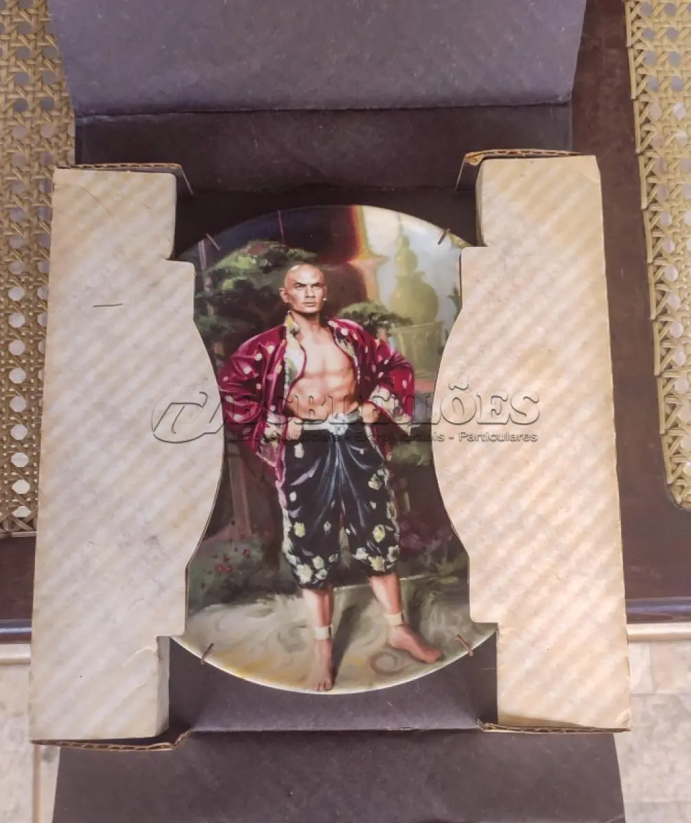 LOTE 017 - 01 ADORADO PRATO DE COLECIONADOR INTITULADO "UM ENIGMA" É UM PRATO DE COLECIONADOR DE EDIÇÃO LIMITADA DA SÉRIE  "THE KING AND" "EM PORTUGUES O REI E EU", DE KNOWLES.PINTADO À MÃO POR WILLIAM CHAMBERS. VENDIDO APENAS POR 150 DIAS E LOGO FOI ENCERRADA AS VENDAS NOS EUA.COM NOTA DE COMPRA DATADA EM 27/07/1984 EM 1980.O PRATO MEDE APROXIMADAMENTE 21 CM E ESTÁ EM EXCELENTE ESTADO.NÚMERO DO PRATO: 19725G.COM CAIXA E CERTIFICADO, MANTIDO EM CASA LIVRE DE FUMO.PEÇA COMPRADA EM GARAGEM DE ANTIGUIDADES NOS EUA. “SUPORTE PARA PRATO NÃO INCLUÍDO NESTA VENDA.”ITEM COMPRADO EM GARAGENS DE ANTIGUIDADES NOS EUA. (NO ESTADO) ATENÇÃO! FAZER A VISITAÇÃO ANTES DE ARREMATAR, NÃO SABEMOS SE FUNCIONA, LEILÃO NÃO TEM GARANTIA E NEM DEVOLUÇÃO, SUJEITO A POSSÍVEIS AVARIAS VISÍVEIS/OCULTAS E/OU AUSÊNCIA DE COMPONENTES.