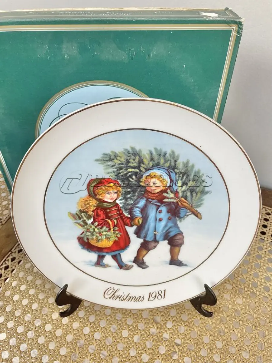 LOTE 058 - 01 PRATO DE NATAL COLECIONÁVEL DA AVON CHRISTMAS MEMORIAS DE 1981, O PRIMEIRO DA SÉRIE. COMPRANDO EM LOJA DE ANTIGUIDADES NO JAPÃO. COM ACABAMENTO EM OURO 22K, APRESENTA UMA MARAVILHOSA CENA VINTAGE DE UM MENINO E UMA MENINA LEVANDO A ÁRVORE E AS PLANTAS PARA CASA PARA AS FESTAS DE FIM DE ANO. CORES E DETALHES LINDOS. EM ÓTIMO ESTADO, COM LEVE DESGASTE NA BORDA INFERIOR DO PRATO E LEVES ARRANHÕES. COM CAIXA. TEM 23 CM DE DIÂMETRO.SUPORTE PARA PRATO NÃO INCLUÍDO NESTA VENDA. (NO ESTADO) ATENÇÃO! FAZER A VISITAÇÃO ANTES DE ARREMATAR, NÃO SABEMOS SE FUNCIONA, LEILÃO NÃO TEM GARANTIA E NEM DEVOLUÇÃO, SUJEITO A POSSÍVEIS AVARIAS VISÍVEIS/OCULTAS E/OU AUSÊNCIA DE COMPONENTES.