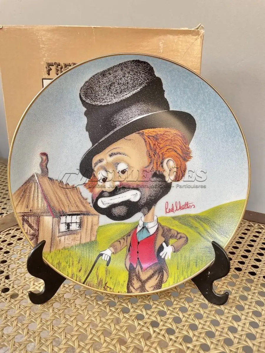 LOTE 064 - 01 PRATO VINTAGE DE COLECIONADOR, DESENHO DE PALHAÇO INTITULADO "FREDDIE'S SHACK" DE RED SKELTON  PEÇA ASSINADO PELO ARTISTA. TEM UM DESIGN MULTICOLORIDO E COLORIDO. PEÇA PRODUZIDO NOS ESTADOS UNIDOS DE CERÂMICA DE ALTA QUALIDADE COM 21 CM DE DIÂMETRO , É UMA PEÇA DE EDIÇÃO LIMITADA DO FINAL DO SÉCULO XX (1980-1989). TIRAGEM: DE 8147/10,000 ESTE PRATO É PERFEITO PARA COLECIONADORES DE ITENS COM TEMÁTICA CIRCENSE E PARA AQUELES QUE APRECIAM A ARTE DE PEÇAS VINTAGE. COM CAIXA ORIGINAL. ITEM COMPRADO EM GARAGEM DE ANTIGUIDADES NOS EUA.SUPORTE PARA PRATO NÃO INCLUÍDO NESTA VENDA. (NO ESTADO) ATENÇÃO! FAZER A VISITAÇÃO ANTES DE ARREMATAR, NÃO SABEMOS SE FUNCIONA, LEILÃO NÃO TEM GARANTIA E NEM DEVOLUÇÃO, SUJEITO A POSSÍVEIS AVARIAS VISÍVEIS/OCULTAS E/OU AUSÊNCIA DE COMPONENTES.