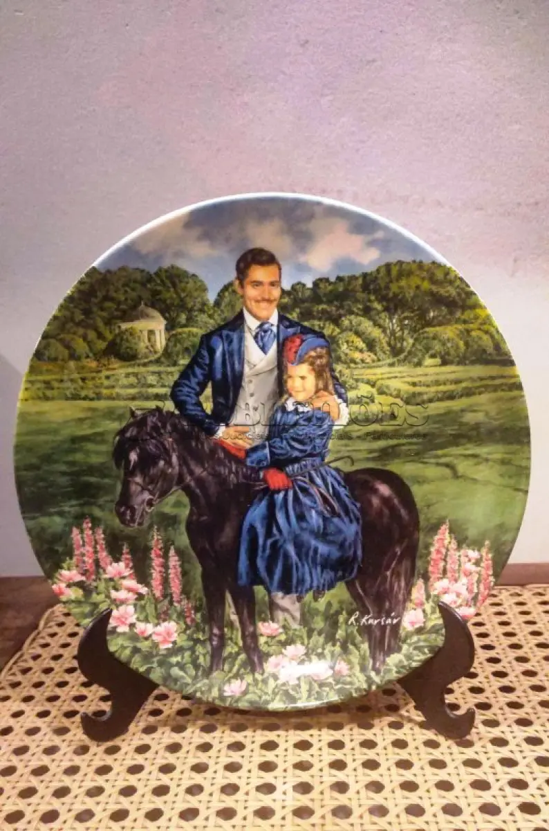 LOTE 260 - 01 PRATO VINTAGE DE COLECIONADOR DA COLEÇÃO E O VENTO LEVOU - "BONNIE E RHETT", DISTRIBUÍDOS PELA THE BRADFORD EXCHANGE DESDE A DÉCADA DE 1980. ESTA É A 8ª PLACA EMITIDA NA SÉRIE E FOI FEITA EM 1981 PELA EDWIN M KNOWLES COLLECTION COM DESIGN DO ARTISTA RAYMOND KURSAR. O PRATO É DE PORCELANA FINA E MEDE 21,5 CM DE DIÂMETRO. O PRATO ESTÁ EM BOM ESTADO, NA CAIXA ORIGINAL, COM DOCUMENTAÇÃO E CERTIFICADO DE AUTENTICAÇÃO. A CAIXA APRESENTA SINAIS DE DESGASTE E MANCHAS POR TER SIDO GUARDADA NA GARAGEM HÁ ANOS. ÓTIMO ITEM COLECIONÁVEL DE "E O VENTO LEVOU". O SUPORTE PARA PRATOS MOSTRADO NAS FOTOS NÃO ESTÁ INCLUSO.ITEM COMPRADO E GARAGENS DE ANTIGUIDADES NOS EUA. SUPORTE PARA PRATO NÃO INCLUÍDO NESTA VENDA. (NO ESTADO) ATENÇÃO! FAZER A VISITAÇÃO ANTES DE ARREMATAR, NÃO SABEMOS SE FUNCIONA, LEILÃO NÃO TEM GARANTIA E NEM DEVOLUÇÃO, SUJEITO A POSSÍVEIS AVARIAS VISÍVEIS/OCULTAS E/OU AUSÊNCIA DE COMPONENTES.