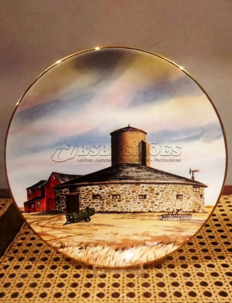 LOTE 316 - 01 RARO PRATO PORCELANA DA COLEÇÃO CELEIROS AMERICANOS EM EXTINÇÃO FRANCISCANA DA HISTORIC PROVIDENCE MINT WORLD PREMIER FIRST EDITION, DE 1983, DA SÉRIE THE VANISHING AMERICAN BARN, DA HARRIS HIEN, A SEGUNDA EDIÇÃO DA SÉRIE, INTITULADA "ROUND  BARN". EM PORTUGUES “CELEIRO REDONDO” O PRATO APRESENTA UMA REPRESENTAÇÃO ÚNICA, DETALHADA E COLORIDA DE UM TIPO DE CELEIRO AMERICANO, SITUADO EM UM CENÁRIO DE FAZENDA DE DIFERENTES REGIÕES DO PAÍS, COM DETALHES DOURADOS NA BORDA. ESTAMPADAS NA PARTE INFERIOR COM O NOME DA SÉRIE, TÍTULO, ASSINATURA IMPRESSA DO ARTISTA E A MARCA THE HISTORIC PROVIDENCE MINT, E MEDEM APROXIMADAMENTE 21,8 CM DE DIÂMETRO. EM EXCELENTE ESTADO, POSSUI A CAIXA ORIGINAL E OS DOCUMENTOS. O SUPORTE DO PRATO NÃO ESTÁ INCLUÍDO. PEÇA COMPRADA EM GARAGEM DE ANTIGUIDADES NOS EUA. SUPORTE PARA PRATO NÃO INCLUÍDO NESTA VENDA. (NO ESTADO) ATENÇÃO! FAZER A VISITAÇÃO ANTES DE ARREMATAR, NÃO SABEMOS SE FUNCIONA, LEILÃO NÃO TEM GARANTIA E NEM DEVOLUÇÃO, SUJEITO A POSSÍVEIS AVARIAS VISÍVEIS/OCULTAS E/OU AUSÊNCIA DE COMPONENTES.