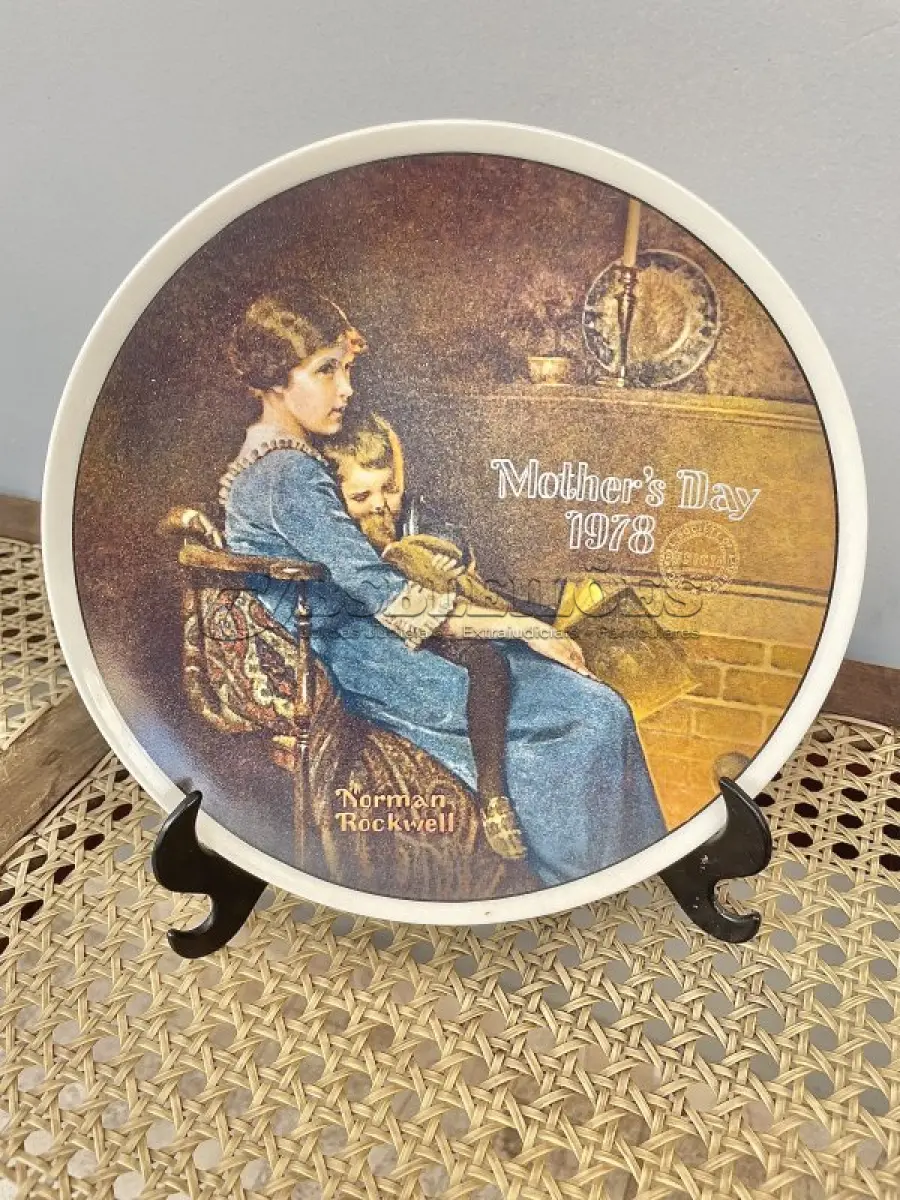 LOTE 129 - 01 PRATO NORMAN ROCKWELL PARA O DIA DAS MÃES – HORA DE DORMIR, 1978. ESTE SERIA UM ÓTIMO PRESENTE PARA QUALQUER PESSOA NASCIDA EM 1978 OU PARA TODAS AS MÃES, PRATO DE PORCELANA FINA DA SÉRIE LIMITADA FECHADA PERMANENTEMENTE EM 28 DE ABRIL DE 1978 POR KNOWLES "BEDTIME", DEDICADA AO DIA DAS MÃES, COMPRADO NOVO NA THE BRADFORD EXCHANGE EM 1978 E FABRICADO PELA KNOWLES FINE CHINA. A IMAGEM FOI CRIADA PELO ARTISTA NORMAN ROCKWELL E É CERTIFICADA PELA ROCKWELL SOCIETY OFF AMÉRICA. OS PRATOS DA SÉRIE "DIA DAS MÃES" ERAM LANÇADOS ANUALMENTE E EXIBIAM O ANO DE EMISSÃO E A PALAVRA "DIA DAS MÃES" DECORATIVAMENTE GRAVADA EM CADA FACE DO PRATO. ITEM COMPRADO EM GARAGEM DE ANTIGUIDADES NOS EUA OBSERVAÇÃO: O SUPORTE DE MOSTRADO NAS FOTOS NÃO ESTÁ INCLUÍDO. (NO ESTADO) ATENÇÃO! FAZER A VISITAÇÃO ANTES DE ARREMATAR, NÃO SABEMOS SE FUNCIONA, LEILÃO NÃO TEM GARANTIA E NEM DEVOLUÇÃO, SUJEITO A POSSÍVEIS AVARIAS VISÍVEIS/OCULTAS E/OU AUSÊNCIA DE COMPONENTES.