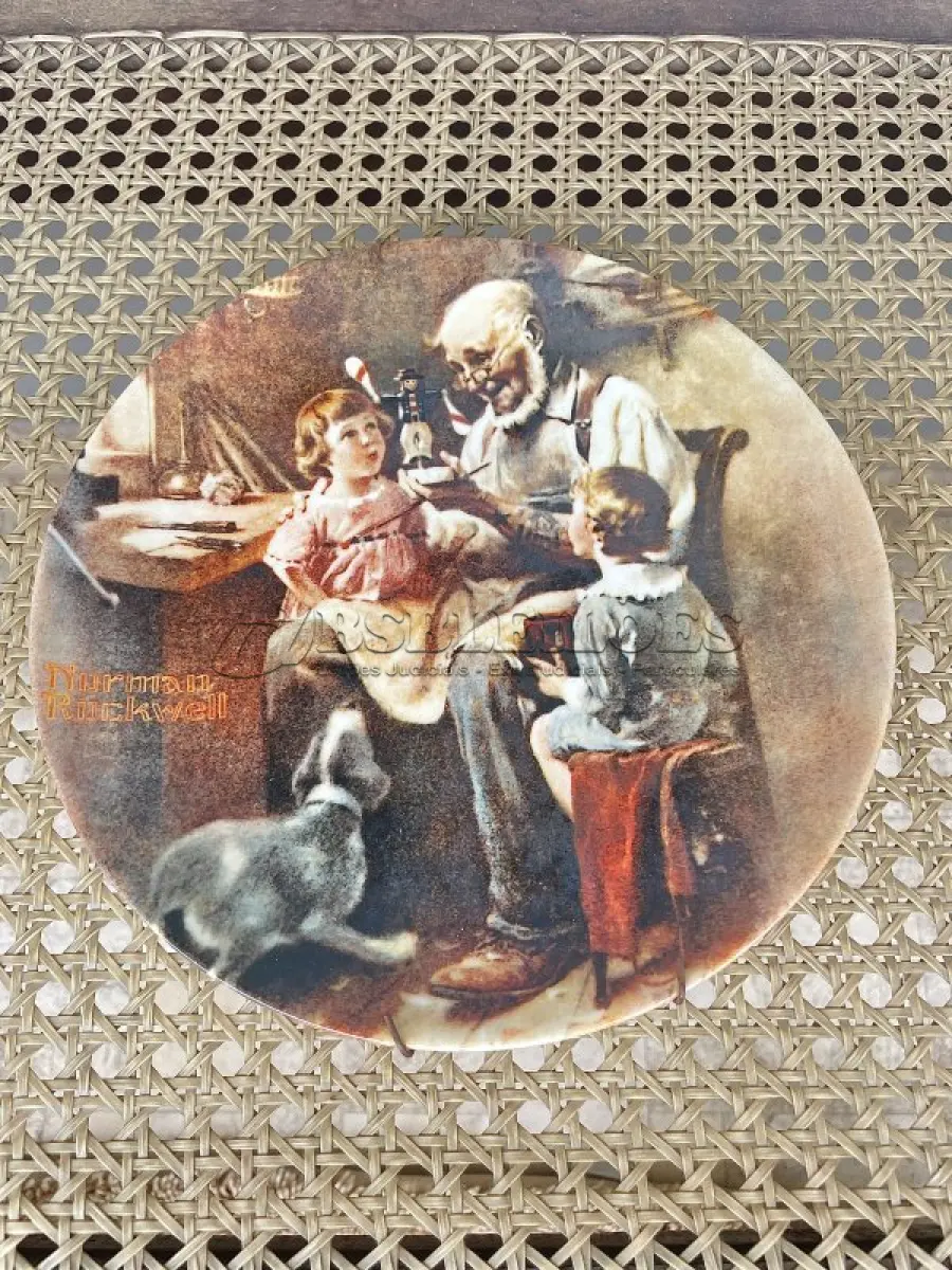 LOTE 271 - 01 PRATO THE TOY MAKER PRIMEIRO PARTO DE  ROCKWELL HERITAGE COLLECTION KNOWLES NORMAN ROCKWELL DATADO EM 1977 . ESTA É A PRIMEIRA PLACA DE COLECIONADOR DE EDIÇÃO LIMITADA Nº9857 D "THE TOY MAKER" DE NORMAN ROCKWELL NA HERITAGE COLLECTION. FOI FEITO À MÃO EM UMA EDIÇÃO LIMITADA PERMANENTEMENTE FECHADA EM 1977 POR KNOWLES E CERTIFICADA COMO "TRUE ROCKWELL CLASSIC" PELA ROCKWELL SOCIETY OF AMERICA.RETRATA UM VELHO FAZENDO UM BRINQUEDO COM UM MENINO E UMA MENINA OLHANDO ATENTAMENTE. HÁ UM CACHORRO ABAIXO DELES OLHANDO COM INTERESSE. COM TODA PAPELADA INCLUÍDA. CERTIFICADO DE AUTORIZAÇÃO DE USO (COA) E LIVRETO DE HISTÓRICO E CERTIFICADO DE AUTENTICIDADE. CAIXA ORIGINAL INCLUÍDA,. MEDE 21,5 CM DE DIÂMETRO. PROVÉM DE UMA COLEÇÃO PARTICULAR GUARDADA A ANOS NOS EUA.ITEM COMPRADO EM GARAGEM DE ANTIGUIDADES NOS EUA. SUPORTE PARA PRATO NÃO INCLUÍDO NESTA VENDA. (NO ESTADO) ATENÇÃO! FAZER A VISITAÇÃO ANTES DE ARREMATAR, NÃO SABEMOS SE FUNCIONA, LEILÃO NÃO TEM GARANTIA E NEM DEVOLUÇÃO, SUJEITO A POSSÍVEIS AVARIAS VISÍVEIS/OCULTAS E/OU AUSÊNCIA DE COMPONENTES.