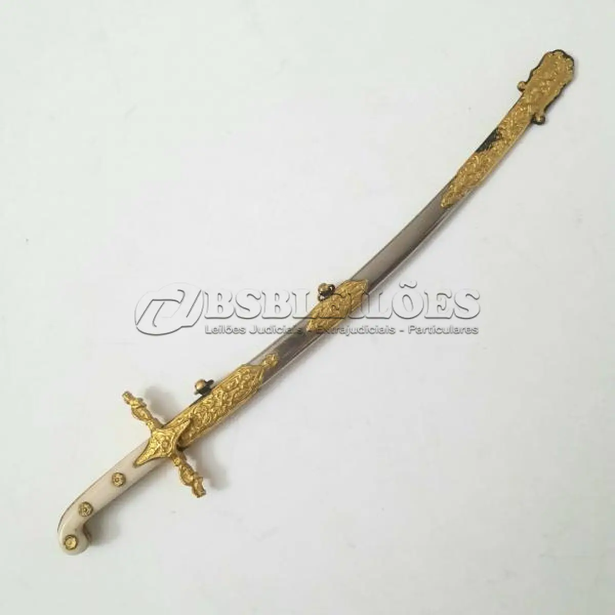 LOTE 115 - 01 MINIATURA DE ESPADA DA MARINHA EM METAL. LÂMINA CINZELADA DE  DUQUE DE CAIXAS  RJ. DA DECADA DE 80 BAINHA DE METAL COM APLIQUES EM METAL DOURADO,COM 15 CM DE CUMPRIMENTO. (NO ESTADO) ATENÇÃO! FAZER A VISITAÇÃO ANTES DE ARREMATAR, NÃO SABEMOS SE FUNCIONA, LEILÃO NÃO TEM GARANTIA E NEM DEVOLUÇÃO, SUJEITO A POSSÍVEIS AVARIAS VISÍVEIS/OCULTAS E/OU AUSÊNCIA DE COMPONENTES.
