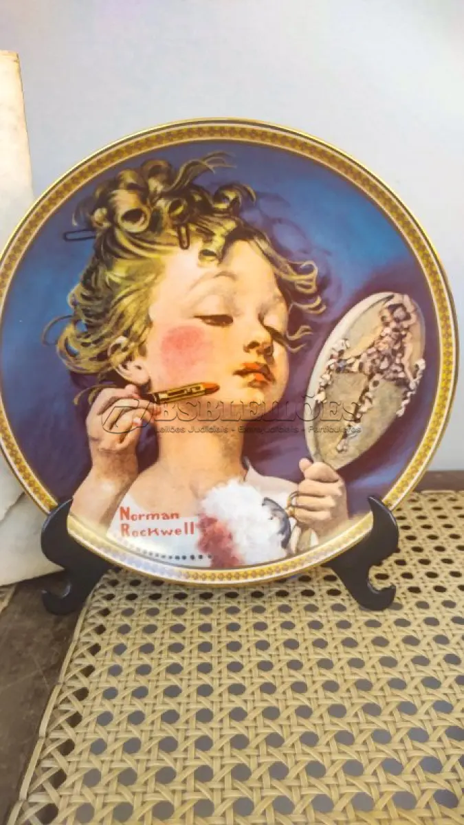 LOTE 147 - 01 RARO PRATO PARA AMANTES E COLECIONADORES DE NORMAN ROCKWELL! ESTE É UM PRATO COLECIONÁVEL DE PORCELANA VINTAGE DE EDIÇÃO LIMITADA. "MAKING BELIEVE AT THE MIRROR" DE NUMERO 16209M É A QUARTA PLACA DA COLEÇÃO DE EDIÇÃO LIMITADA INTITULADA ROCKWELL'S REDISCOVERED WOMEN, UMA SÉRIE QUE OFERECE UMA RETROSPECTIVA ÚNICA DAS OBRAS DE NORMAN ROCKWELL. ESTA OBRA É OFICIALMENTE CERTIFICADA PELA ROCKWELL SOCIETY OF AMERICA. FOI ENCONTRADA EM UM ARMÁRIO DURANTE A VENDA DE UMA PROPRIEDADE, APÓS MUITOS ANOS GUARDADA.  CAIXA ORIGINAL E CERTIFICADO DE AUTENTICIDADE DA PEÇA  O PRATO MEDE 21,5 CM DE DIÂMETRO.  SUPORTE PARA PRATO NÃO INCLUÍDO NESTA VENDA. (NO ESTADO) ATENÇÃO! FAZER A VISITAÇÃO ANTES DE ARREMATAR, NÃO SABEMOS SE FUNCIONA, LEILÃO NÃO TEM GARANTIA E NEM DEVOLUÇÃO, SUJEITO A POSSÍVEIS AVARIAS VISÍVEIS/OCULTAS E/OU AUSÊNCIA DE COMPONENTES.
