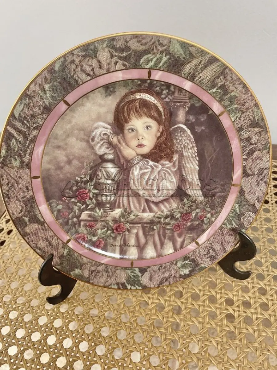 LOTE 291 - 01PRATO IMPECÁVEL E RARO IMPECÁVEL GARDENS OF INNOCENCE DONNA RICHARDSON HOPE É A EDIÇÃO 1 DA SÉRIE DE 8 PLACAS PARA COLECIONADORES, GARDEN OF INNOCENCE, DE DONNA RICHARDSON PARA A BRADFORD EXCHANGE DE 1993. ESTA SÉRIE, GARDEN OF INNOCENCE, REÚNE CRIANÇAS ANGELICAIS EM UM CENÁRIO DE JARDIM ONÍRICO. CADA PLACA POSSUI UMA BORDA TRIPLA DE TAPEÇARIA E DESIGN EM ÔNIX. PEÇA VINTAGE COLACIONÁVEL 2ª EDIÇÃO BRADFORD EXCHANGE. SAFRA 1993. EDIÇÃO LIMITADA. PLACA NUMERADA. .COM 20 CM DE DIÂMETRO COM UMA FAIXA EM OURO 22K, HOPE TEM DURAÇÃO LIMITADA A 95 DIAS DE QUEIMA DE ESTOQUE E LOGO FOI FECHADA A FABRICAÇÃO DA MESMA. NA EMBALAGEM ORIGINAL DE ISOPOR COM CERTIFICADO E FOLHETO DA ÉPOCA. (NO ESTADO) ATENÇÃO! FAZER A VISITAÇÃO ANTES DE ARREMATAR, NÃO SABEMOS SE FUNCIONA, LEILÃO NÃO TEM GARANTIA E NEM DEVOLUÇÃO, SUJEITO A POSSÍVEIS AVARIAS VISÍVEIS/OCULTAS E/OU AUSÊNCIA DE COMPONENTES.