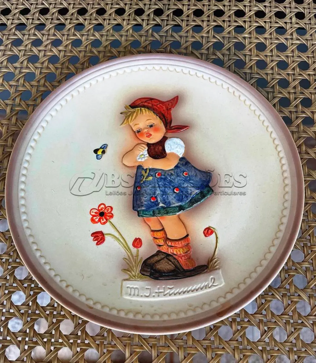 LOTE 313 - 01 RARO PRATO DE PORCELANA LINDAMENTE TRABALHADO DA FAMOSA M.J. HUMMEL GOEBEL APRESENTA UM FORMATO REDONDO E DESIGN MULTICOLORIDO, PERFEITO PARA TODAS AS OCASIÕES E ESTILOS DE DECORAÇÃO. É UM ITEM DE COLECIONADOR DA SEGUNDA EDIÇÃO DO PRATO VALENTINE JOY, GRAVADO COM DETALHES INTRINCADOS E FABRICADO NA ALEMANHA NA DÉCADA DE 1980.TERCEIRA EDIÇÃO DE UMA SÉRIE DE QUATRO PRATOS LANÇADOS PEÇA ÚNICA DA CULTURA ALEMÃ E VEM DA FRANQUIA GOEBEL, COM 16 CM DE DIÂMETROUMA MARCA RENOMADA NO SETOR DE COLECIONÁVEIS ​​DECORATIVOS. LANÇADA SOMENTE PARA MEMBROS DO CLUBE DE COLECIONADORES GOEBEL. ITEM COMPRADO EM GARAGENS DE ANTIGUIDADES NOS EUA.SUPORTE PARA PRATO NÃO INCLUÍDO NESTA VENDA. (NO ESTADO) ATENÇÃO! FAZER A VISITAÇÃO ANTES DE ARREMATAR, NÃO SABEMOS SE FUNCIONA, LEILÃO NÃO TEM GARANTIA E NEM DEVOLUÇÃO, SUJEITO A POSSÍVEIS AVARIAS VISÍVEIS/OCULTAS E/OU AUSÊNCIA DE COMPONENTES.