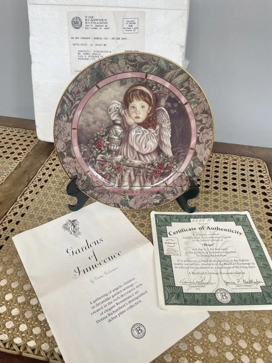 LOTE 291 - 01PRATO IMPECÁVEL E RARO IMPECÁVEL GARDENS OF INNOCENCE DONNA RICHARDSON HOPE É A EDIÇÃO 1 DA SÉRIE DE 8 PLACAS PARA COLECIONADORES, GARDEN OF INNOCENCE, DE DONNA RICHARDSON PARA A BRADFORD EXCHANGE DE 1993. ESTA SÉRIE, GARDEN OF INNOCENCE, REÚNE CRIANÇAS ANGELICAIS EM UM CENÁRIO DE JARDIM ONÍRICO. CADA PLACA POSSUI UMA BORDA TRIPLA DE TAPEÇARIA E DESIGN EM ÔNIX. PEÇA VINTAGE COLACIONÁVEL 2ª EDIÇÃO BRADFORD EXCHANGE. SAFRA 1993. EDIÇÃO LIMITADA. PLACA NUMERADA. .COM 20 CM DE DIÂMETRO COM UMA FAIXA EM OURO 22K, HOPE TEM DURAÇÃO LIMITADA A 95 DIAS DE QUEIMA DE ESTOQUE E LOGO FOI FECHADA A FABRICAÇÃO DA MESMA. NA EMBALAGEM ORIGINAL DE ISOPOR COM CERTIFICADO E FOLHETO DA ÉPOCA. (NO ESTADO) ATENÇÃO! FAZER A VISITAÇÃO ANTES DE ARREMATAR, NÃO SABEMOS SE FUNCIONA, LEILÃO NÃO TEM GARANTIA E NEM DEVOLUÇÃO, SUJEITO A POSSÍVEIS AVARIAS VISÍVEIS/OCULTAS E/OU AUSÊNCIA DE COMPONENTES.