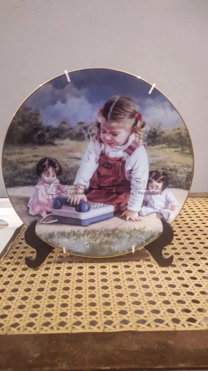 LOTE 288 - 01 RARO PRATO "CHATTERBOX" VINTAGE DE 1984, MOMENTOS ESPECIAIS DE LUCELLE RAAD,4ª EDIÇÃO DA SÉRIE "MOMENTOS ESPECIAIS" CONCEITOS MODERNOS DE 1984,LIMITADO A APENAS 12.500 CÓPIAS EM TODO O MUNDO Nº 271, ESTE PRATO DE COLECIONADOR DA MODERN CONCEPTS, LTD. É UMA BELA ADIÇÃO A QUALQUER COLEÇÃO. O PRATO APRESENTA UM DESIGN COLORIDO, FORMATO REDONDO E 21,5 CM DE DIÂMETRO. FOI FEITO EM PORCELANA NO FINAL DO SÉCULO XX, ESPECIFICAMENTE EM 1984. O PRATO FAZ PARTE DA SÉRIE SECRETS SPECIAL MOMENTS, CRIADA POR LUCELLE RAAD, E TEM COMO TEMA CRIANÇAS. É UM ITEM VINTAGE E FOI FABRICADO NOS ESTADOS UNIDOS. ESTE PRATO DECORATIVO DE COLECIONADOR É PERFEITO PARA TODAS AS OCASIÕES E SERIA UM ÓTIMO COMPLEMENTO PARA QUALQUER DECORAÇÃO.EM EXCELENTE ESTADO, POSSUI A CAIXA ORIGINAL CERTIFICADO DE AUTENTICIDADE E OS DOCUMENTOS. O SUPORTE DO PRATO NÃO ESTÁ INCLUÍDO. PEÇA COMPRADA EM GARAGEM DE ANTIGUIDADES NOS EUA. (NO ESTADO) ATENÇÃO! FAZER A VISITAÇÃO ANTES DE ARREMATAR, NÃO SABEMOS SE FUNCIONA, LEILÃO NÃO TEM GARANTIA E NEM DEVOLUÇÃO, SUJEITO A POSSÍVEIS AVARIAS VISÍVEIS/OCULTAS E/OU AUSÊNCIA DE COMPONENTES.