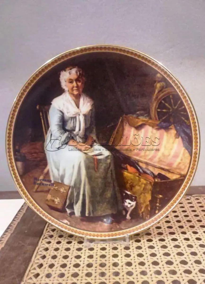 LOTE 315 - 01 PRATO COLECIONÁVEL EMITIDO PELA KNOWLES CHINA.ESTA EDIÇÃO LIMITADA É UM DESIGN DE NORMAN ROCKWELL E É CHAMADA DE "REMINISCING IN THE QUIET" (REMINISCÊNCIAS NO SILÊNCIO).DA "REDISCOVERED WOMEN COLLECTION" DE ROCKWELL. ROCKWELL REALMENTE RETRATOU A SIMPLICIDADE DA VIDA AMERICANA, AQUELES MOMENTOS RICOS QUE TODOS NÓS VALORIZAMOS. O PRATO COM 21,5 CM DE  DIÂMETRO. NUMERADO 14489K.UMA EDIÇÃO LIMITADA, ORIGINAL OX E COA INCLUÍDOS. ÓTIMA COR, ESTILO E CONDIÇÃO. COM CERTIFICADO DE AUTENTICIDADE E OS FOLHETOS ORIGINAL DA ÉPOCA E NOTA DE COMPRA DATA EM, 28/05/1981.ITEM COMPRADO E GARAGENS DE ANTIGUIDADES NOS EUA. SUPORTE PARA PRATO NÃO INCLUÍDO NESTA VENDA. (NO ESTADO) ATENÇÃO! FAZER A VISITAÇÃO ANTES DE ARREMATAR, NÃO SABEMOS SE FUNCIONA, LEILÃO NÃO TEM GARANTIA E NEM DEVOLUÇÃO, SUJEITO A POSSÍVEIS AVARIAS VISÍVEIS/OCULTAS E/OU AUSÊNCIA DE COMPONENTES.