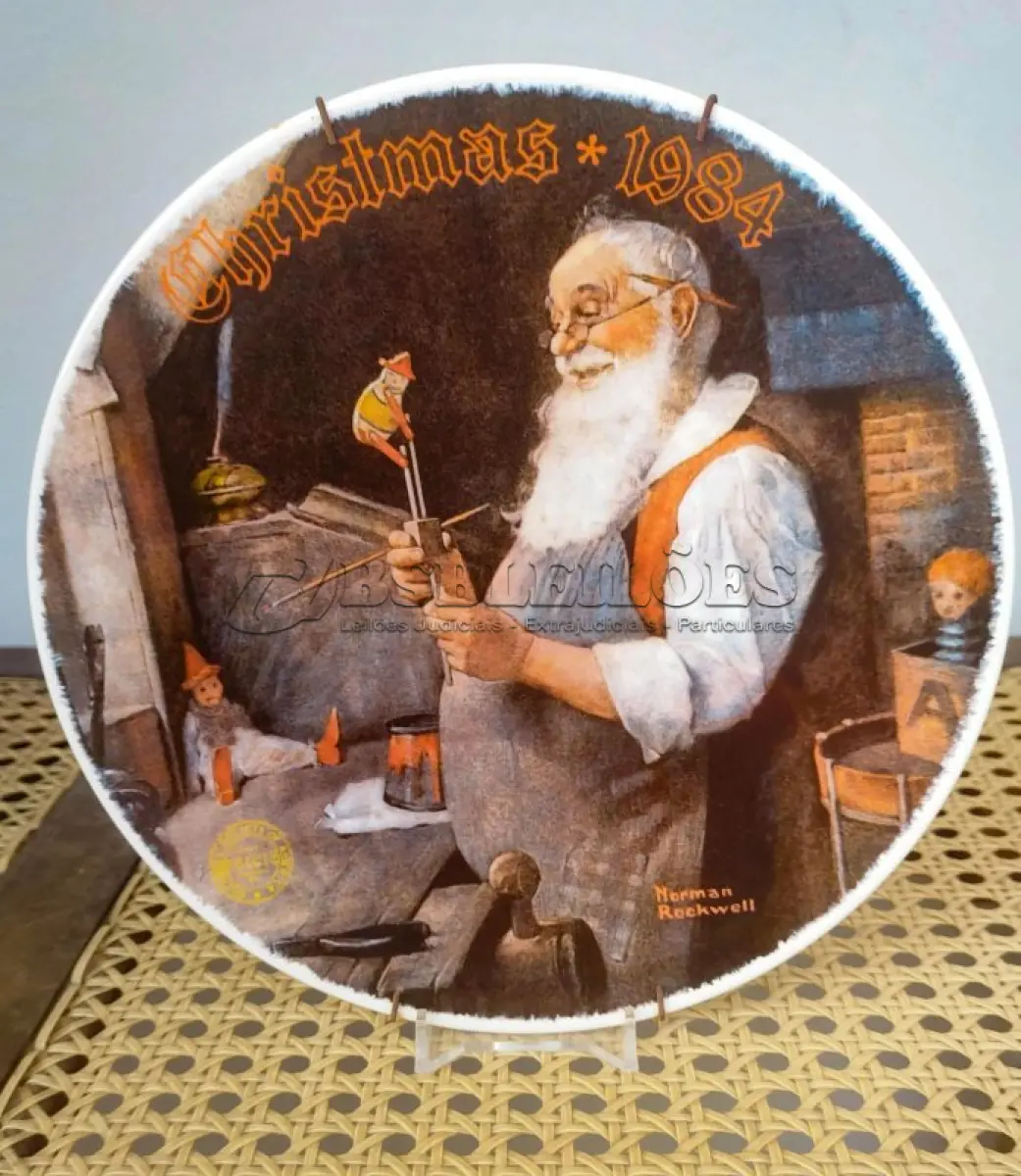 LOTE 340 - 01 PRATO DE NORMAN ROCKWELL EDIÇÃO DA SAFRA 1984 PORCELANA FINA ESTA É PARTE DA PLACA DE EDIÇÃO LIMITADA DA THE ROCKWELL SOCIETY OF AMERICA Nº DA ÚNICA EDIÇÃO NOMEADA PAPAI NOEL EM SUA OFICINA POR NORMAN ROCKWELL É A DÉCIMA PRIMEIRA EDIÇÃO DE UMA SÉRIE ANUAL DE PLACAS EDIÇÃO PERMANENTEMENTE FECHADA VISUAL MURAL PINTADO EM 1922 POR NORMAN ROCKWELL FEITO POR EDWIN M KNOWLES NOME MAIS ANTIGO DA AMÉRICA EM PORCELANA FINA NÚMERO BRADEX 84-R70-1.11 PRATO DE NUMERO 17170 C CERTIFICADO DE AUTENTICAÇÃO OFICIALMENTE CARIMBADO CARIMBADO E ASSINADO, QUE É COMO SEU TÍTULO NA PARTE DE TRÁS,  COM CAIXA ORIGINAL COM PARTE DA ETIQUETA DO SELO THE BRADFORD EXCHANGE COM UM PANFLETO DA HISTÓRIA DESTA PLACA. MEDE 8 1/4 DE DIÂMETRO SEM ARRANHÕES SEM LASCAS SEM RACHADURAS  ITEM DE COLECIONADOR. ITEM COMPRADO E GARAGENS DE ANTIGUIDADES NOS EUA. SUPORTE PARA PRATO NÃO INCLUÍDO NESTA VENDA. (NO ESTADO) ATENÇÃO! FAZER A VISITAÇÃO ANTES DE ARREMATAR, NÃO SABEMOS SE FUNCIONA, LEILÃO NÃO TEM GARANTIA E NEM DEVOLUÇÃO, SUJEITO A POSSÍVEIS AVARIAS VISÍVEIS/OCULTAS E/OU AUSÊNCIA DE COMPONENTES.
