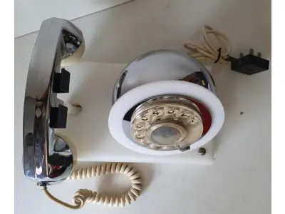 LOTE 084 - RARO TELEFONE ANOS 70. EM PLÁSTICO CROMADO E MECANISMO EM CAIXA DE ACRÍLICO MEDIDAS 24 CM COMP X 14,5 CM LARG X 19 CM ALT (NO ESTADO)