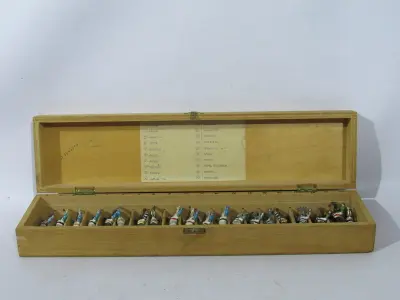 LOTE 078 - COLEÇÃO COM 20  MINIATURAS DE CAVALOS DE CORRIDA ANTIGOS DÉCADA DE 80 COM  JÓQUEIS EM CHUMBO, POLICROMADA, NO ESTOJO DE MADEIRA COM DIVISÓRIAS OBS DUAS MINIATURAS FALTANDO UMA PERNA (NO ESTADO)