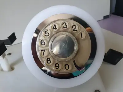 LOTE 084 - RARO TELEFONE ANOS 70. EM PLÁSTICO CROMADO E MECANISMO EM CAIXA DE ACRÍLICO MEDIDAS 24 CM COMP X 14,5 CM LARG X 19 CM ALT (NO ESTADO)