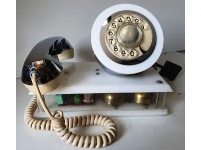 LOTE 084 - RARO TELEFONE ANOS 70. EM PLÁSTICO CROMADO E MECANISMO EM CAIXA DE ACRÍLICO MEDIDAS 24 CM COMP X 14,5 CM LARG X 19 CM ALT (NO ESTADO)