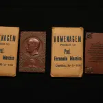 LOTE 020 - LOTE 20 – MEDALHAS FERNANDO MOREIRA 	MEDALHA	OBSERVAÇÕES 1.		Homenagem ao Professor Fernando Augusto Moreira. 1938. Gravador: José Peón	Acobreada - envelope original da medalha. 2.		Homenagem ao Professor Fernando Augusto Moreira. 1938. Gravador: José Peón	Acobreada - envelope original da medalha.