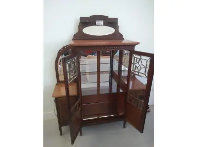 LOTE 040 - 01 CRISTALEIRA ANTIGA IMBUIA COM DETALHES ENTALHADOS NAS PORTAS, ESPELHOS LATERAIS, COM PORTA ENVIDRAÇADA EM CRISTAL BISOTADO. (NO ESTADO DE CONSERVAÇÃO QUE SE ENCONTRA) 