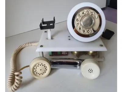LOTE 084 - RARO TELEFONE ANOS 70. EM PLÁSTICO CROMADO E MECANISMO EM CAIXA DE ACRÍLICO MEDIDAS 24 CM COMP X 14,5 CM LARG X 19 CM ALT (NO ESTADO)