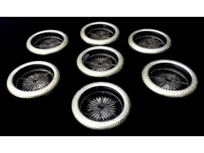 LOTE 142 - CONTEMPORÂNEO JOGO COM 7 PORTA COPOS EM VIDRO TRANSLÚCIDO COM BASE ESTRELADA E BORDA ADORNADA EM ALUMÍNIO MARTELADO. MED 9CM DIÂM X 1,5CM ALT (NO ESTADO)