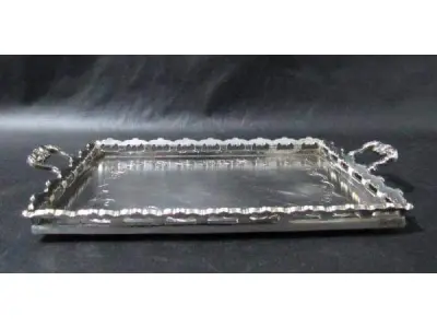 LOTE 290 - DOIS COPOS EM CRISTAL TRANSLÚCIDO COM SUPORTE DE METAL PRATEADO UMA (1) BANDEJA EM FORMATO RETANGULAR CONFECCIONADO EM METAL ESPESSURADO A PRATA 26,4 CM DE COMPRIMENTO (NO ESTADO)