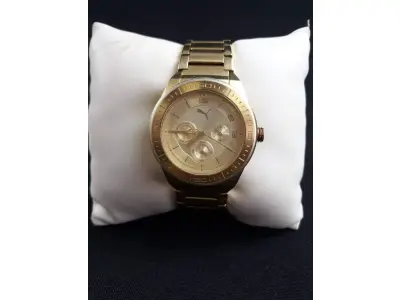 LOTE 275 - RELÓGIO PUMA , RESISTENTE ÁGUA , PULSEIRA EM AÇO DOURADO , ACOMPANHA PEÇAS PARA AJUSTE NA  PULSEIRA , COM  BATERIA NOVA  (NO ESTADO)