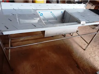 LOTE 183 - 01 BANCADA COM PIA CENTRAL E ESPELHO MEDINDO 180CMX66CM EM AÇO INOX. (NOVO) (NO ESTADO, NÃO SABEMOS SE FUNCIONA. LEILÃO NÃO TEM GARANTIA E NEM DEVOLUÇÃO).