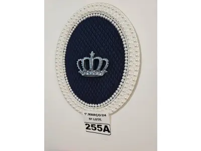 LOTE 255 - 01 QUADRO OVAL COM FUNDO EM TECIDO METALACÊ AZUL MARINHO, CORÔA DE RESINA ENVELHECIDO NO TOM AZUL E COM TOQUE PRATEADO(PINTADO À MÃO) E FINALIZADA NO VENIZ COM PÉROLAS BRANCAS (MEDIDAS: 40CMX32CM) (NOVO) (NO ESTADO)