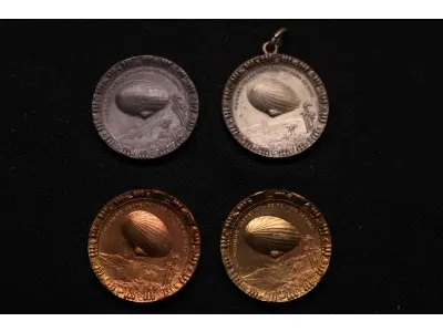LOTE 031 - LOTE 31 – MEDALHAS CONDE ZEPPELIN 	MEDALHA	OBSERVAÇÕES 1.		Medalha Conde Zeppelin. Curitiba. 1930  Gravador: José Peón	Prateada – envelope da Coleção Júlio Estrella Moreira 2.		Medalha Conde Zeppelin. Curitiba. 1930  Gravador: José Peón	Chumbo – envelope da Coleção Júlio Estrella Moreira 3.		Medalha Conde Zeppelin. Curitiba. 1930  Gravador: José Peón	Dourada 4.		Medalha Conde Zeppelin. Curitiba. 1930  Gravador: José Peón	Dourada